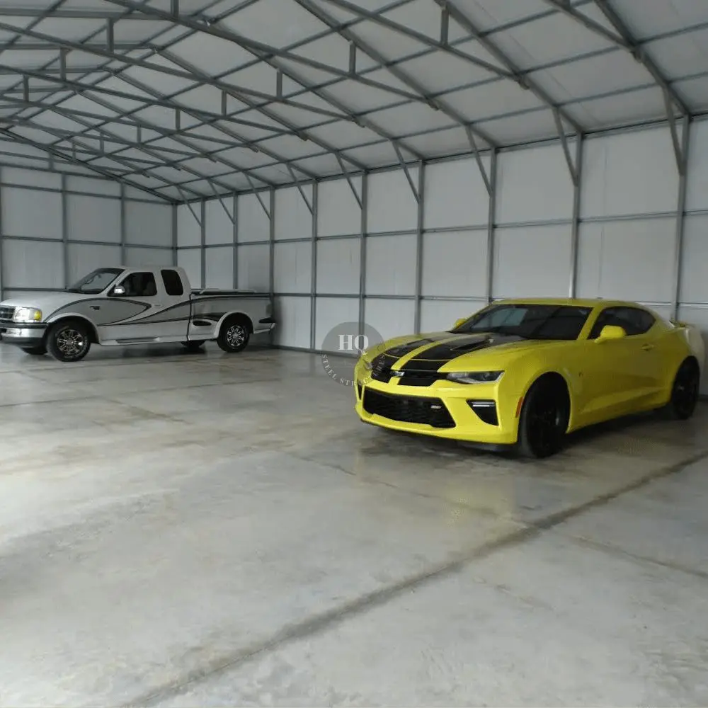 A truck and car in a garage with white walls.